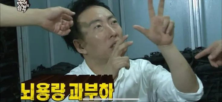 땀에 젖은 셔츠 차림의 남자가 양손으로 얼굴 앞에서 손가락을 펼친 채 넋이 나간 표정을 짓고 있고, 화면 아래에 “뇌용량 과부하”라는 노란 자막이 큼직하게 깔린 예능 프로그램 장면