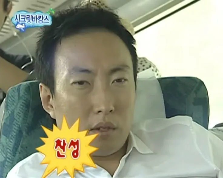 기차 좌석에 기대앉은 남자가 정면을 무표정하게 바라보고 있고, 화면 왼쪽 아래에 노란 폭발 모양 말풍선으로 “찬성”이라는 자막이 붙은 예능 프로그램 장면