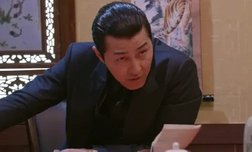 책상 너머로 몸을 기울여 상대를 다그치듯 캐묻는 장면